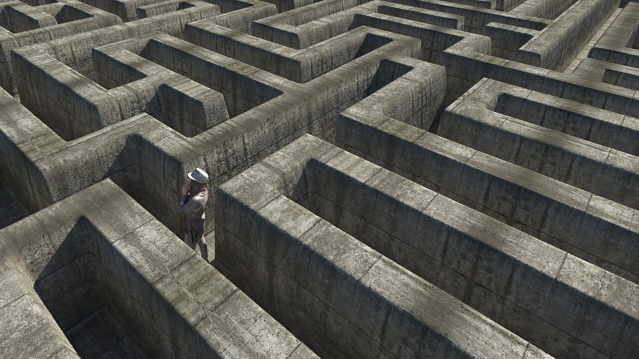 Neurodiversität und Trauma im Business: Traumasensibles Coaching Karen Wiltner Coaching Person steht in einem Labyrinth und sucht nach dem Ausgang, symbolisiert den Versuch, emotionale Blockaden im Business mit dem Yager Code zu überwinden.