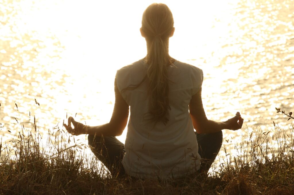 Geschichte und Entwicklung der Yager Methode: Sanfter Weg zur Veränderung Karen Wiltner Coaching Person sitzt entspannt in Meditation, was die sanfte und wirksame Herangehensweise der Yager Methode symbolisiert
