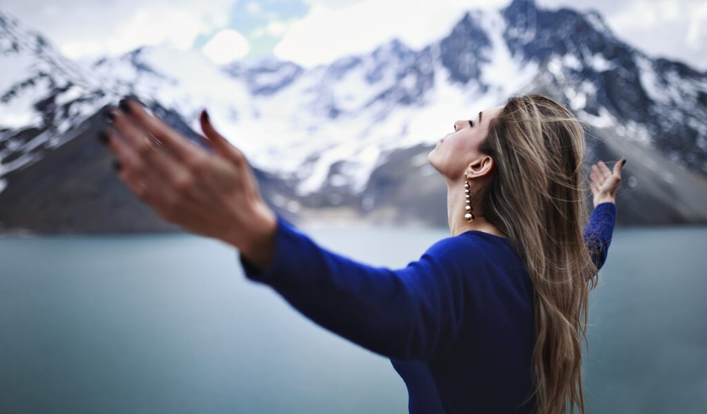 Meine Werte und Visionen: Authentizität, Transformation und emotionale Freiheit Karen Wiltner Coaching Person an einem See auf einem Berggipfel symbolisiert emotionale Freiheit und Transformation