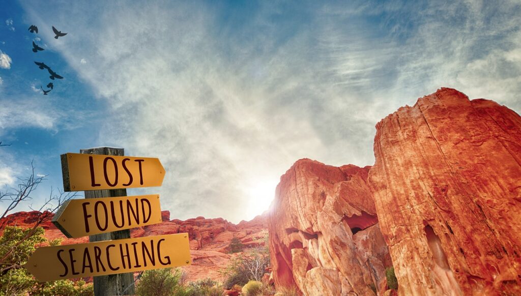 Neuanfang ab 40: Wie Du die Veränderungen meisterst Karen Wiltner Coaching Wegweiser in den Bergen mit den Aufschriften 'Lost', 'Found' und 'Searching', symbolisiert den Neuanfang ab 40 und die Suche nach Orientierung